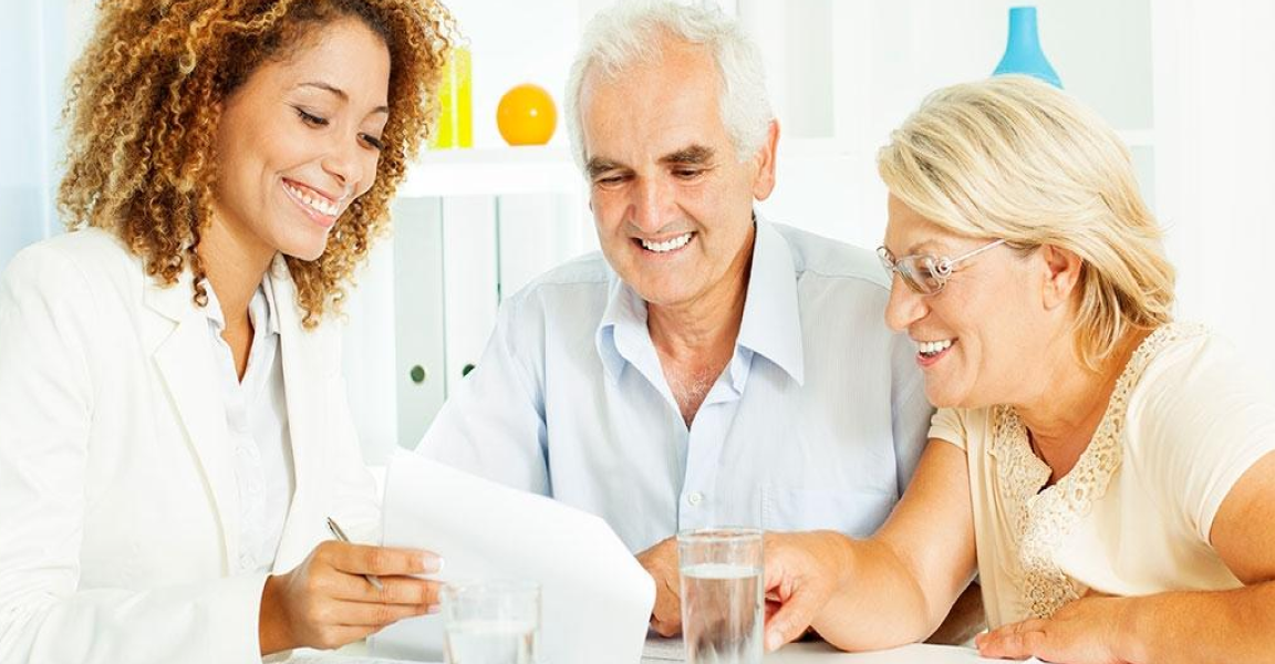 Couple meeting with financial professional and smiling