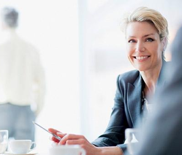 Businesswoman discussing exclusive portfolio management, smiling aver a desk