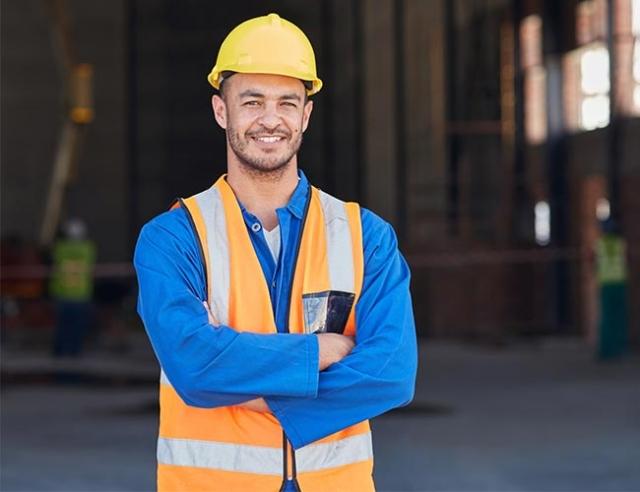 A construction worker stands at a building site