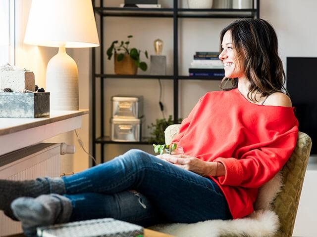 A woman sits in her office, smiling.